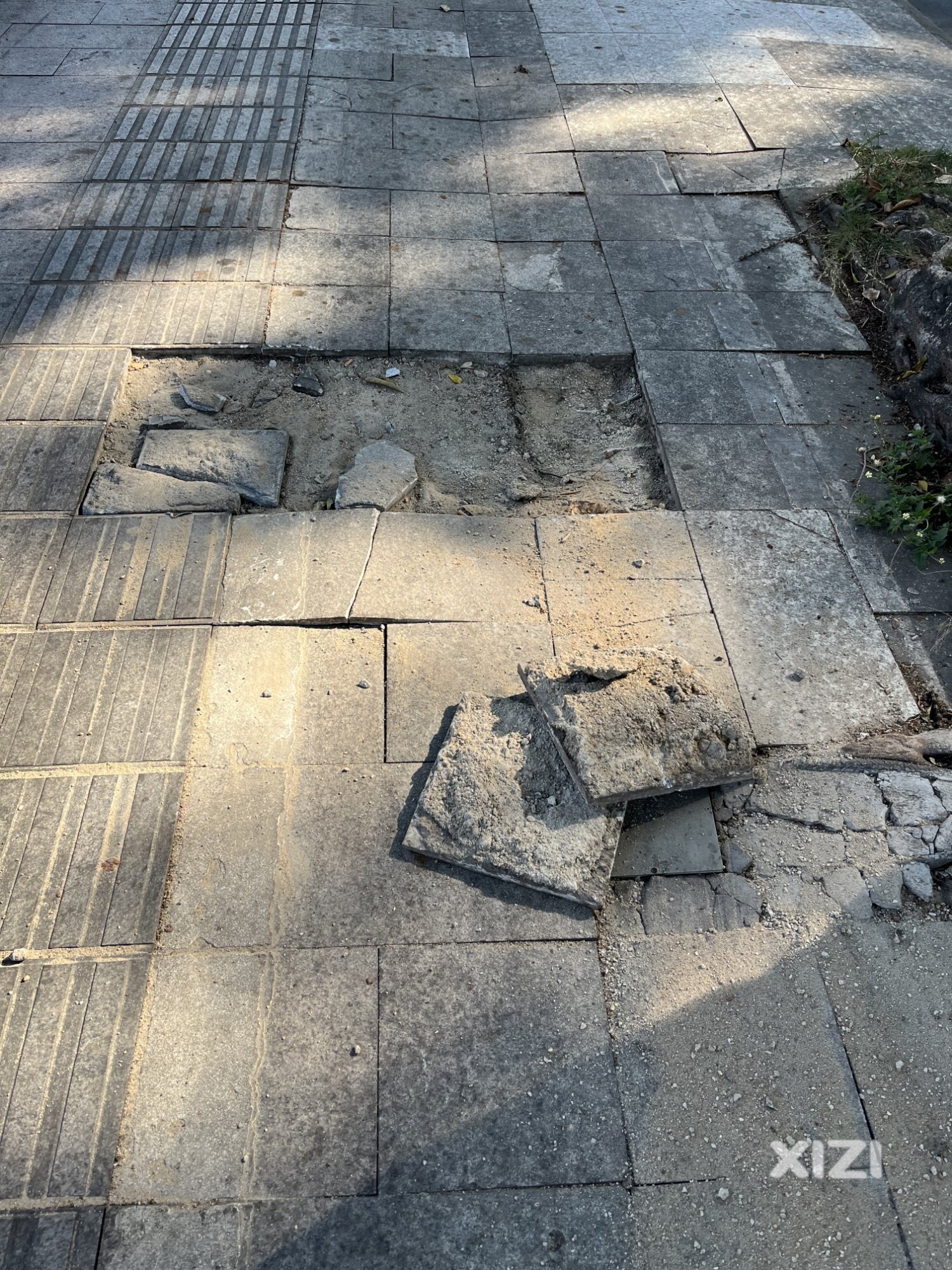 滨江西路的人行道，地砖被人破坏的到处都是坑坑洼洼